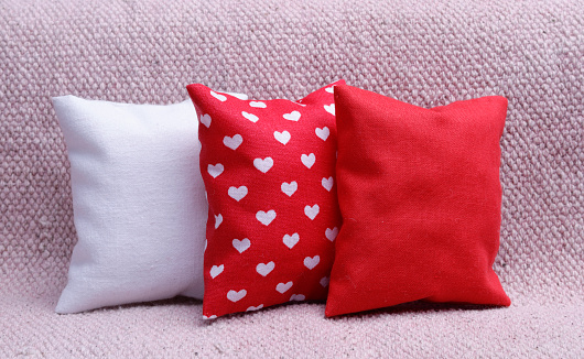 White,red and heart shaped cushions on  the sofa