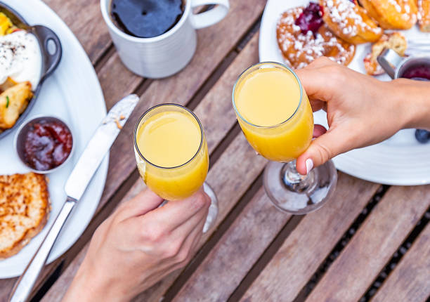 Mimosa Cheers A toast with mimosas brunch stock pictures, royalty-free photos & images