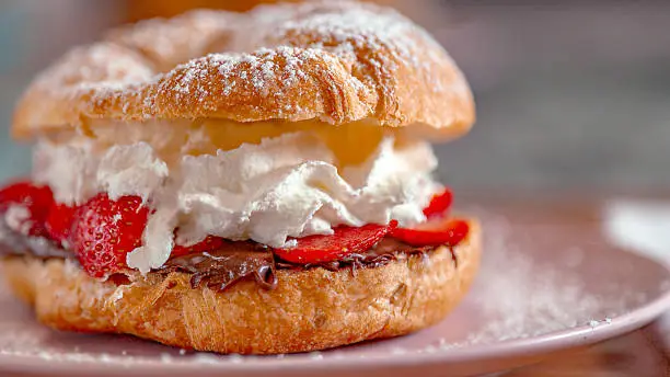 Croissant style pastry filled with whipped cream and strawberries