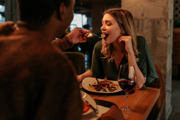 istock Romantic man feeding wife in restaurant. 1462358500