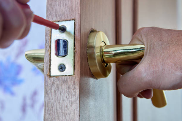 istock Locksmith tightens fixing screw of door latch plate. 1462370482