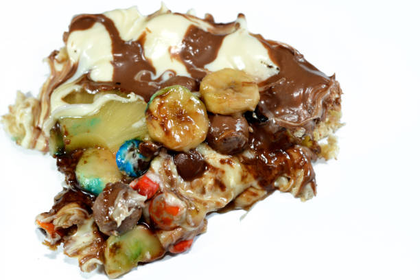 istock Chocolate mixture with biscuit and different types of chocolate pieces and cream with fresh pineapple ananas and bananas pieces on top on a dough baked and ready to be served 1462418988