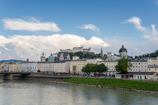 Salzburg, Austria -July 28, 2022: Views of Salzburg from the Marko-Feingold-Steg bridge. It can be seen the Collegiate Church, the Franciscan Church, the Hohensalzburg Fortress, the city hall clock tower, the Cathedral and the Staatsbrücke bridge