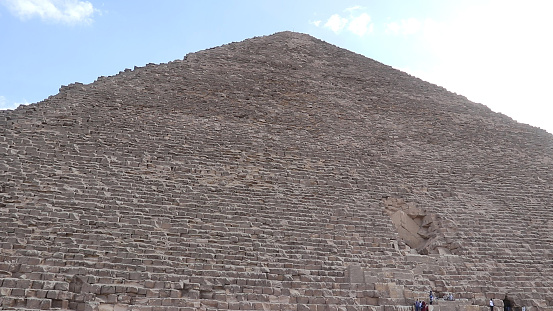 Camel caravan in front of the Great Pyramid of Menkaure in the Giza Pyramid Complex on background Cairo city skyline. Tourists continued to swarm the historic sites at Giza.