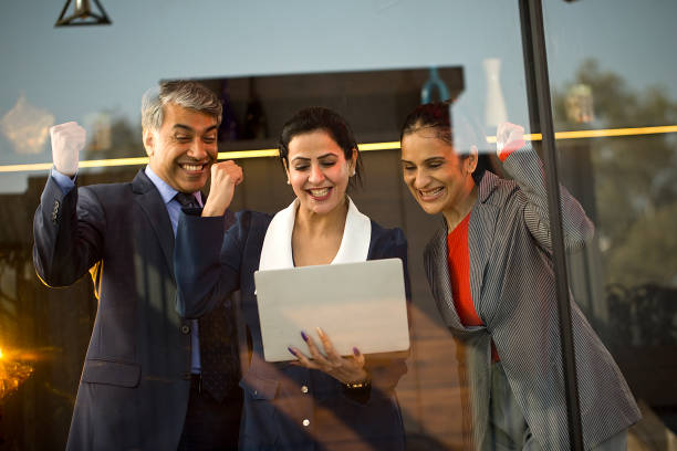 istock Business people celebrating success using laptop at office 1462427869