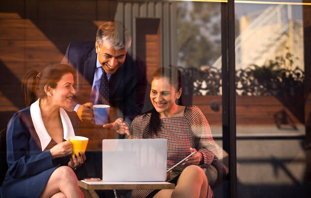 istock Happy business people drinking coffee and using laptop 1462434291