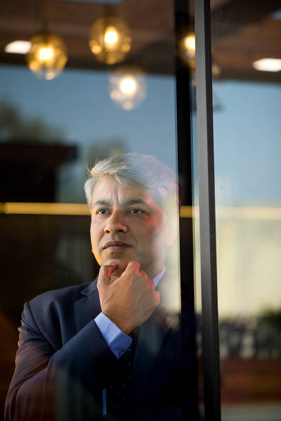 istock Thoughtful businessman looking through glass window 1462434656