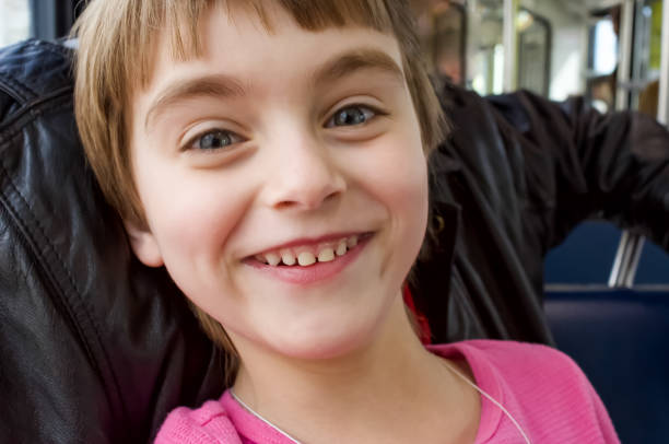 Little girl sits on a transit vehicle.  Excited to be going on an adventure