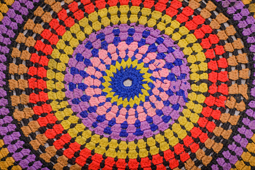 Close up of a multicolored crocheted carpet.