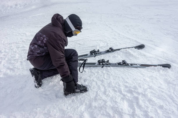 istock Skier getting ready to ski, attaching boots to his feet and checking equipment. 1462448220