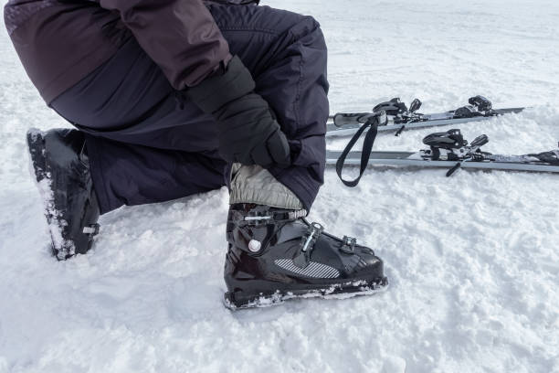istock Skier getting ready to ski, attaching boots to his feet and checking equipment. 1462448221
