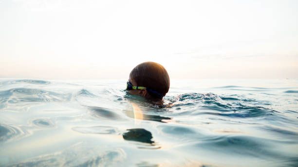 istock Young boy swimming in sea water 1462451032