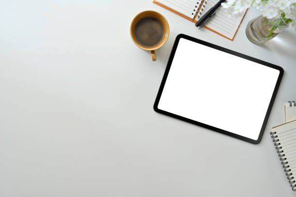 istock Modern workplace wot digital tablet, cup of coffee and notepad on white table. Flat lay, Top view. 1462499382