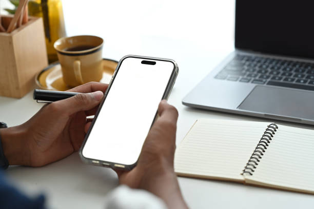 istock Close up view of man sitting on bright office and using smart phone.Empty screen for your advertise design. 1462499385