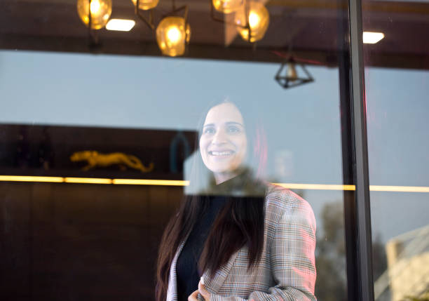 istock Smiling businesswoman looking through window 1462499861