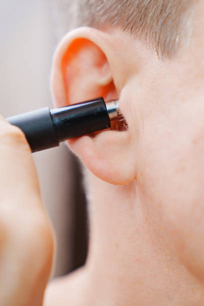 istock close-up. a man cuts his ear hair with a trimmer. 1462501373