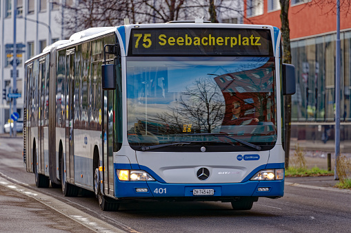 Bus line 75 destination Seebach at City of Zürich district Oerlikon on a sunny winter day arriving at bus station. Photo taken January 31st, 2023, Zurich, Switzerland.
