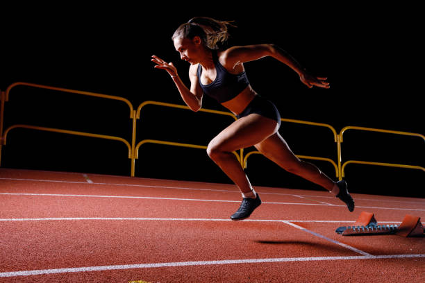 istock Young sportswoman doing explosive start from the starting blocks on her running lane 1462512482