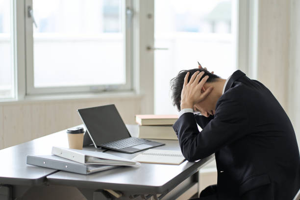 istock Worried asian businessman holding his head 1462512855