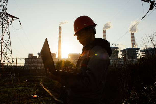 istock At sunset, engineers working in the power plant use computers to command the working posture, silhouette 1462516684
