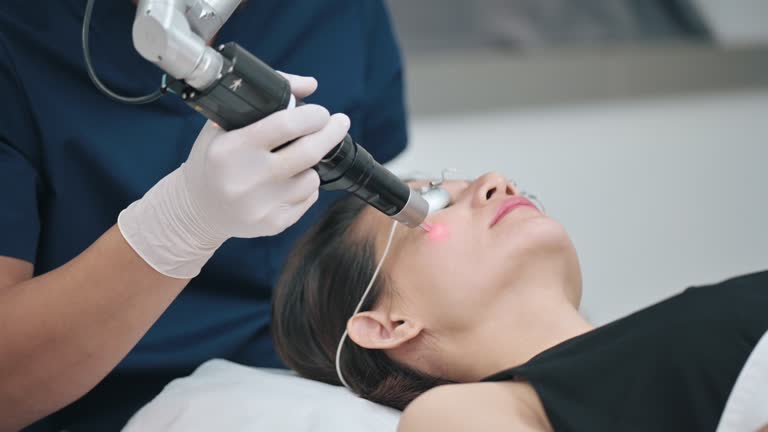 Asian Chinese male Aesthetician laser IPL treatment on his female patient in clinic