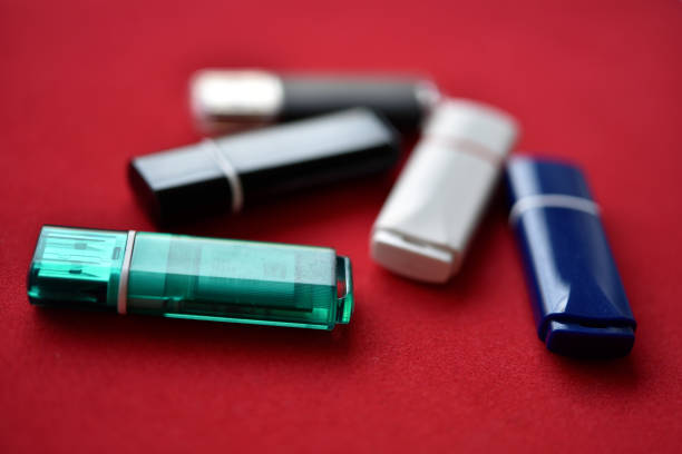 Colored flash drives on a red background. Storage of information. Flash drives in a pile.