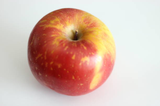 istock Selective focus shot of a red and green apple on the white surface 1462525013