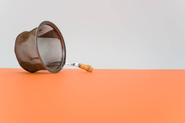 istock metal tea strainer on an orange paper background with copy space 1462530213