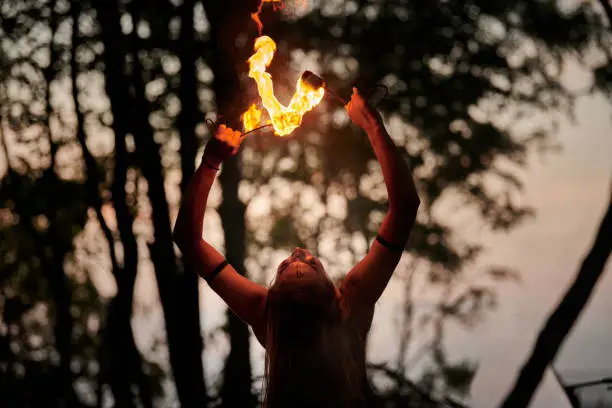 Photo of Girl fire dancing performance at outdoor art festival, smooth movements of female artist