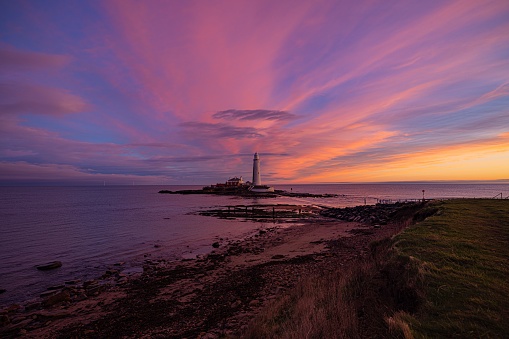 A drone shot of the St Mary's Lighthouse on the coast at sunrise in UK