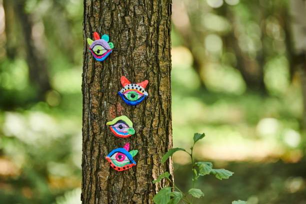 Art object of human eyes on tree trunk in green forest background, trees sight feeling ecological concept