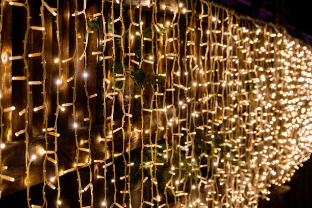istock Christmas lights on strings hanging on railing of bridge. 1462547334