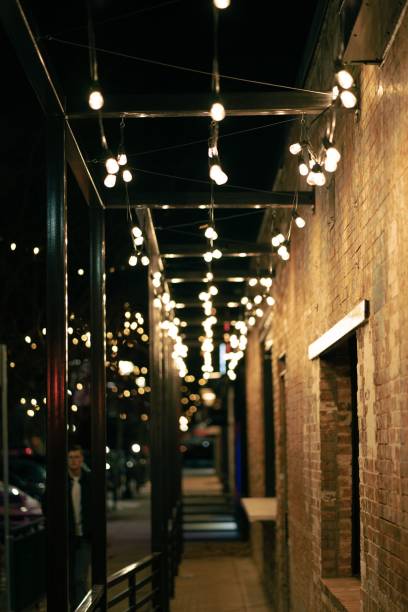 istock Vertical view of a street-side passage designed with light bulbs at night 1462549354