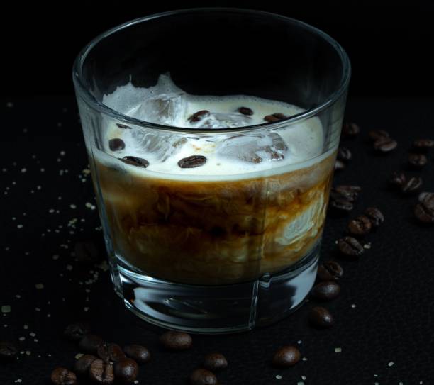 istock Iced coffee drink on a black table with ice cubes and beans in it 1462549448