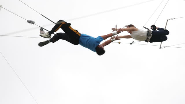 Trapeze artists catching in the sky