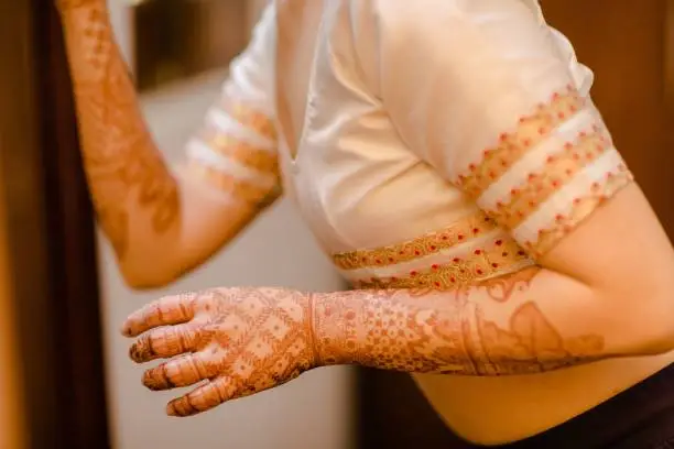 A closeup of the hands of an Indian bride covered in beautiful Bridal henna, mehndi