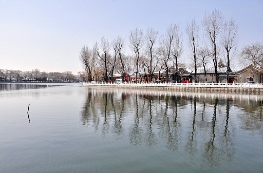 The Houhai Lake with the reflection of buildings and trees in winter in Beijing, China