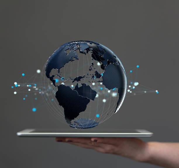 istock Hand holding a tablet with a floating render of a globe- global network connection concept 1462561238