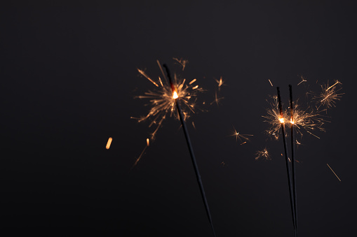 A closeup shot of burning sparklers in the dark