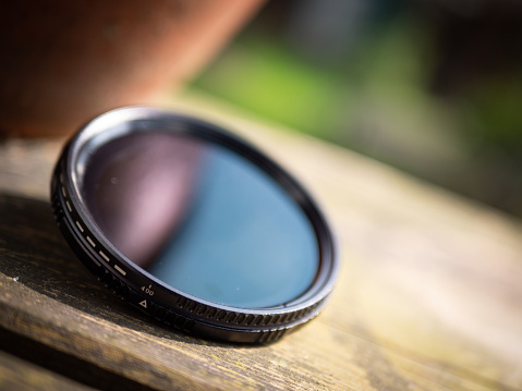 A closeup shot of a thin camera lens on wood