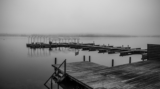 A boat jetty on a foggy winter day at Reifnitz am Worthersee on the south shore of Worthersee, or Worth Lake, in Carinthia, Austria