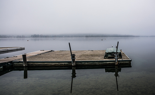 A boat jetty on a foggy winter day at Reifnitz am Worthersee on the south shore of Worthersee, or Worth Lake, in Carinthia, Austria