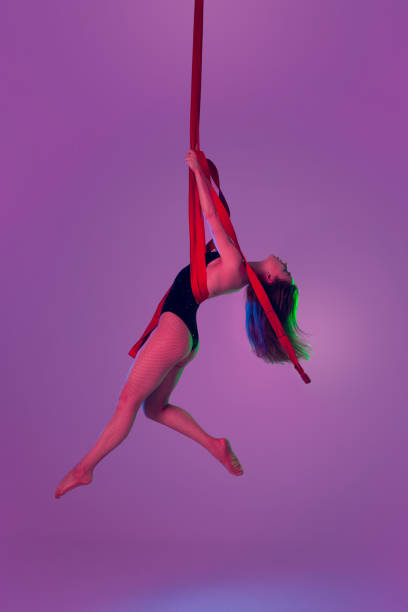 istock Beautiful girl in a black swimsuit is performing an acrobatic elements in studio. 1462584647