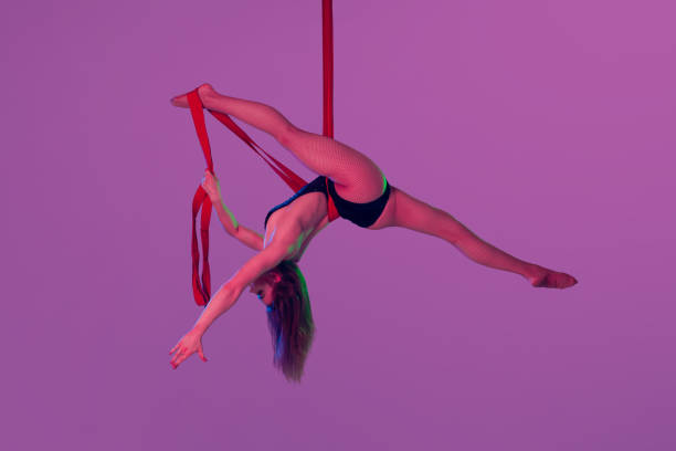 istock Beautiful girl in a black swimsuit is performing an acrobatic elements in studio. 1462586984