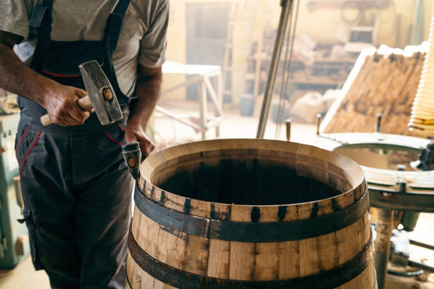 istock Cooper removing metal hoop from a oak barrel 1462591579