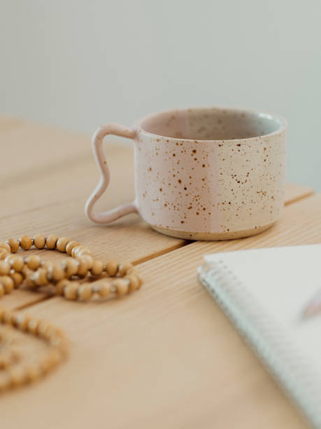 istock Modern still life at home coffee cup note book zen buddha necklace and pen on table 1462592087