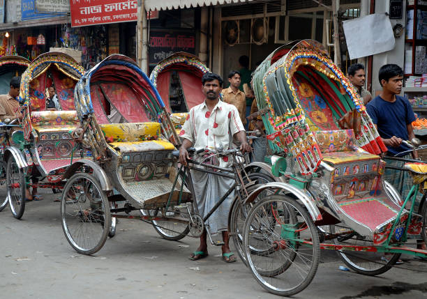 A rickshaw driver in Dhaka, Bangladesh. A line of rickshaws with drivers waiting for business. Local transport, Dhaka, Bangladesh.