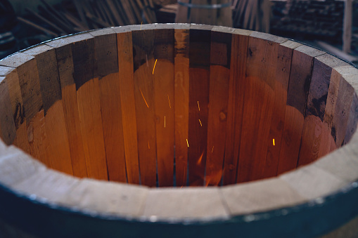 Close-up of an oak barrel burning, to gain aroma for the alcohol which will be stored in it