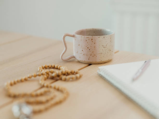 istock Modern still life at home coffee cup note book zen buddha necklace and pen on table 1462593550