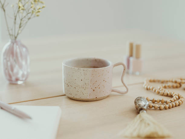istock Modern still life at home coffee cup note book zen buddha necklace and pen on table 1462594652